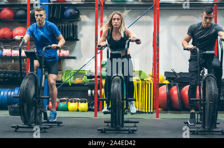 Athletes doing air bike indoor Stock Photo