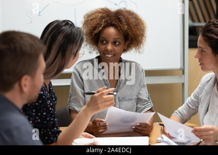 Creative group of businesspeople discussing new project using documents Stock Photo