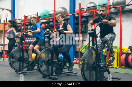 Athletes doing air bike indoor Stock Photo