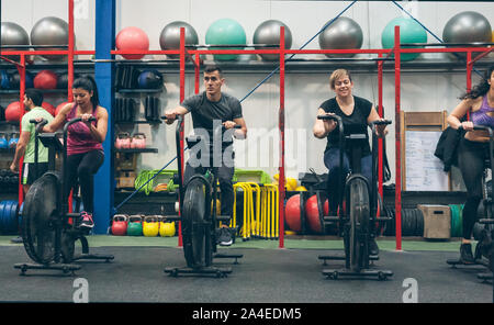 Athletes doing air bike indoor Stock Photo