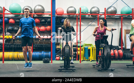 Athletes doing air bike and skipping rope Stock Photo