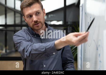 Trainer makes presentation for staff using flipchart during business training Stock Photo