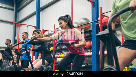 Athletes doing air bike indoor Stock Photo