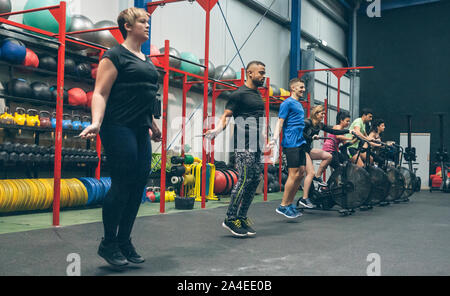 Athletes skipping rope and doing air bike Stock Photo