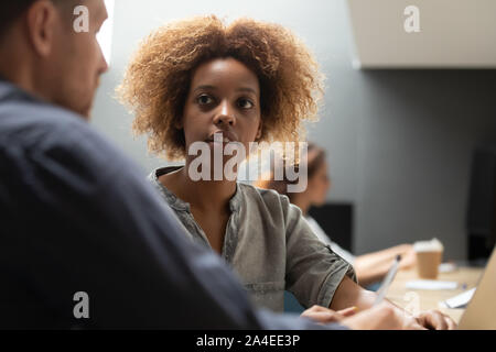 Young african female talking to male coworker having business conversation Stock Photo