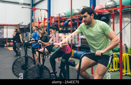 Athletes doing air bike indoor Stock Photo