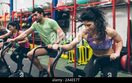 Athletes doing air bike indoor Stock Photo