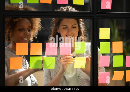 Women colleagues work on project present ideas on sticky notes Stock Photo