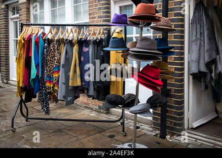 LONDON, ENGLAND - September 15, 2019, Cashmere shawls and felt hats on the rail at the entrance to the store are for sale Stock Photo