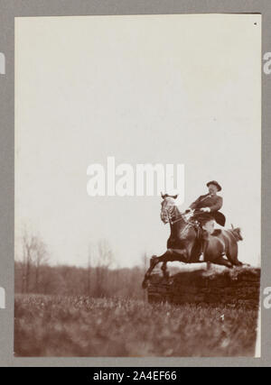 Theodore Roosevelt on horseback jumping over stone wall Stock Photo