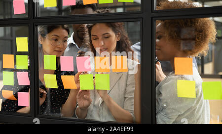 Group of multiracial businesspeople creating business plan using sticky notes Stock Photo