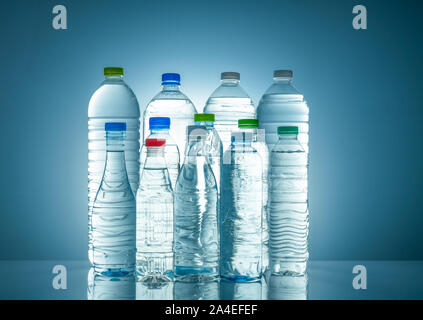 Set of transparent plastic water bottle with blank label. Clear water and natural mineral bottle with white, green, red, and blue cap. Healthy drink. Stock Photo