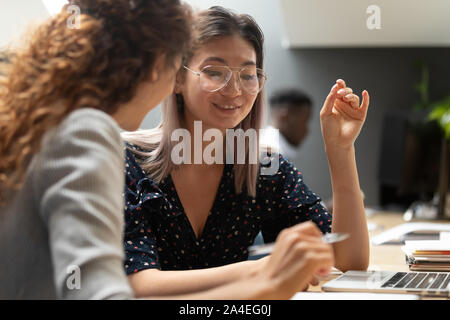 Multiethnic colleagues doing common task using laptop thinking on project Stock Photo