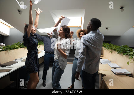 Successful multiethnic workers scream with joy celebrating accomplishment of project Stock Photo