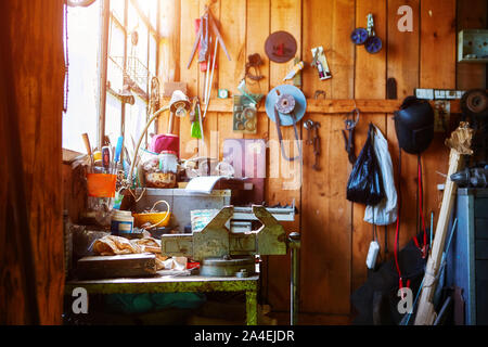 Workshop or garage on a farm in an old wooden barn. A lot of different tools lying around in a mess to repair any equipment. Stock Photo