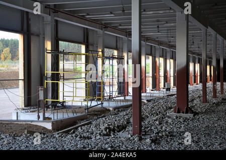 Construction of a warehouse complex, inside view. Columns are installed, crushed stone is laid on the floor. Stock Photo