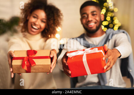 Excited afro couple holding xmas gift boxes and smiling Stock Photo