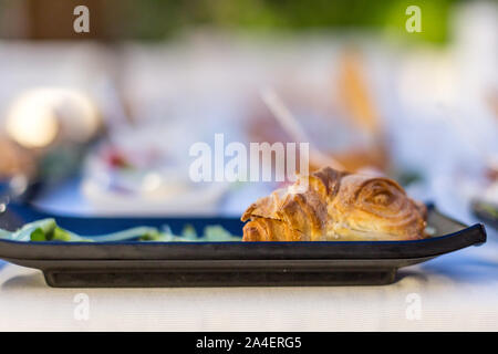 Tasty croissant sandwich with cheese and ham. Stock Photo