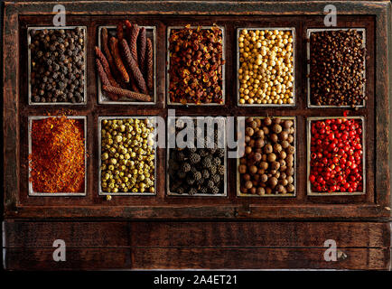 Assortment of peppercorns in a rustic wooden box. Stock Photo