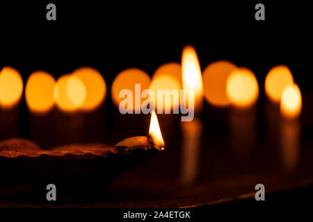 Clay diya lamps & candles lit during diwali celebrations background stock photo. Greetings card design for Indian hindu light festival called Diwali. Stock Photo