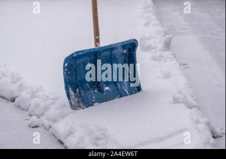 Using snow shovel on a backyard Stock Photo