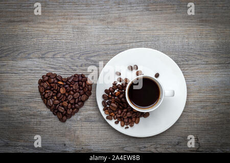 Espresso coffee on a wooden table with coffee beans in the shape of a heart Stock Photo