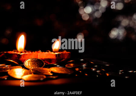 Horizontal plane having two terracotta lamps and coins - Diwali prosperity concept in Hinduism Stock Photo