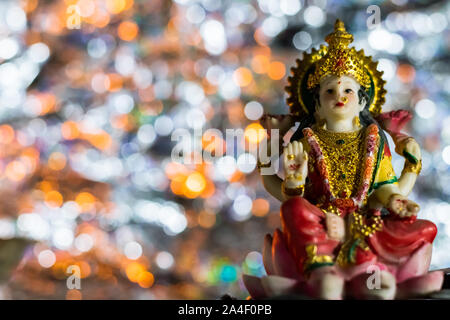 Low-angle shot of the statue of Lakshmi -the Goddess of wealth and prosperity on a Pink-lotus flower in Diwali Pooja Stock Photo