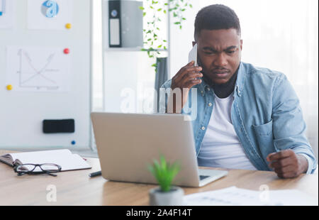 Depressed african american businessman receiving bad news on the phone Stock Photo