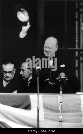 Churchill waving to the crowd from the Ministry of Health building, Whitehall. With him are Ernest Bevin and Sir John Anderson. VE Day  8th May 1945 Stock Photo