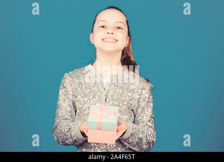 My precious. Special happens every day. Girl with gift box blue background. Black friday. Shopping day. Cute adorable child carry gift box. Surprise gift box. Birthday wish list. World of happiness. Stock Photo
