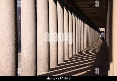 Long colonnade in baroque style in afternoon sun with long shadows. Stock Photo