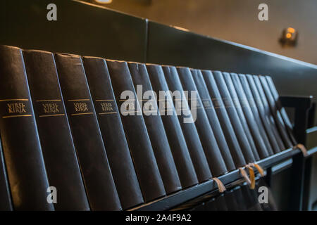 Porvoo, Finland - 2 October 2019: Closeup of a row of green hymn books on finnish language in Porvoo Cathedral. Stock Photo