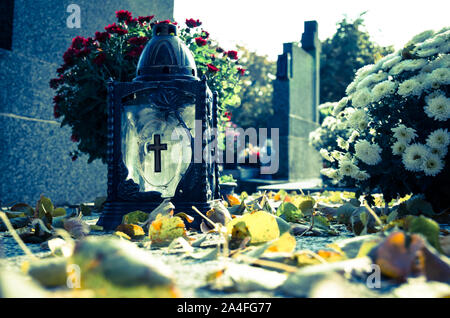 lantern with burning candle on the grave in the cemetery Stock Photo