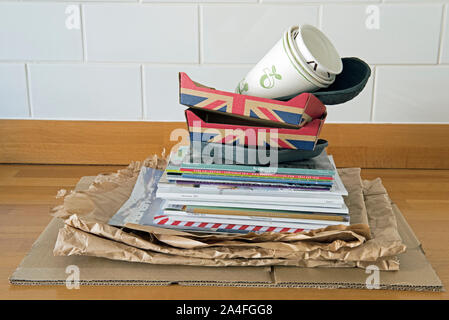 Recyclable household items on kitchen worktop ready for recycling including, paper, cardboard fruit holders and old catalogues.  Zero waste Stock Photo