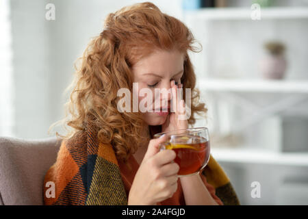 Curly woman having strong headache while having flu Stock Photo