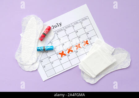 Aspects of women wellness in monthlies period. Menstrual pads and tampons on menstruation period calendar. Woman critical days, gynecological menstrua Stock Photo