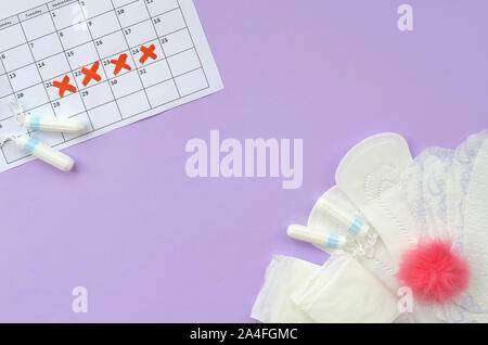 Aspects of women wellness in monthlies period. Menstrual pads and tampons on menstruation period calendar. Woman critical days, gynecological menstrua Stock Photo