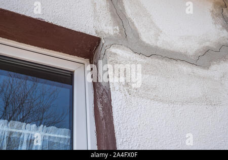 Cracks in a house wall at the window Stock Photo