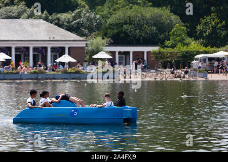 London, UK. A group – one of them asleep – aboard a rented pedalo on the Serpentine in Hyde Park. Stock Photo