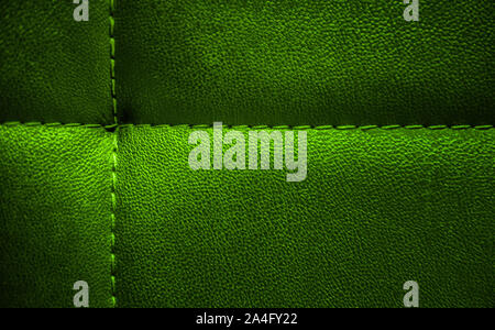 Bright shiny electric green artificial textured leather stitched with  thread. Close-up of sofa surface. View from above. Highly detailed background w Stock Photo