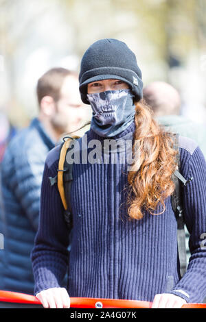 London, UK. A protester wearing a skeleton face mask holds a banner as the Extinction Rebellion protest brings Marble Arch to a standstill. Stock Photo