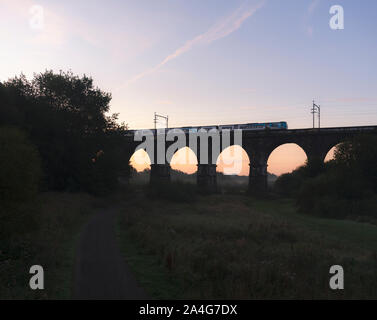 Sankey Viaduct, Earlestown, Cheshire First Transpennine Express class 185 diesel train crossing the viaduct at sunrise Stock Photo