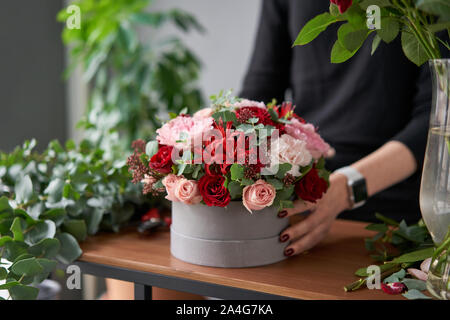 Floral shop concept . Florist woman creates flower arrangement in a round box. Beautiful bouquet of mixed flowers. Handsome fresh bunch. Flowers Stock Photo