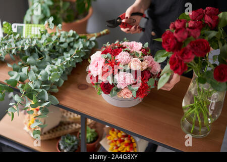 Floral shop concept . Florist woman creates flower arrangement in a round box. Beautiful bouquet of mixed flowers. Handsome fresh bunch. Flowers Stock Photo