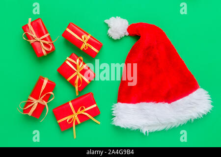 Gift boxes with santa hat on green background Stock Photo