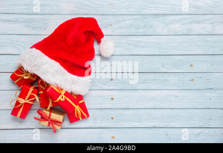 Gift boxes with santa hat on wooden background Stock Photo