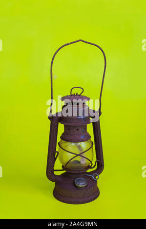 Rusty old oil lamp on a green background Stock Photo