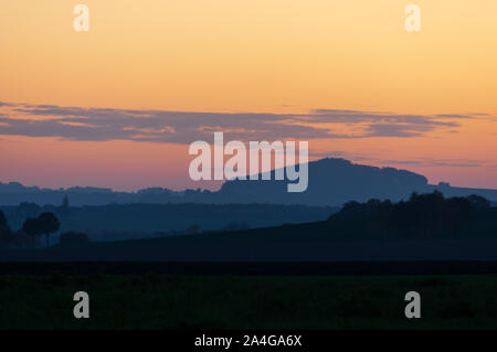 Mount Spitzberg Oberoderwitz in the Lusatian Mountains during blue hour against sunset sky with few clouds Stock Photo