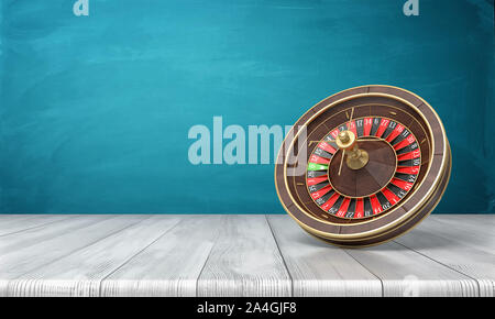 3d rendering of a casino roulette stands on its side on a wooden desk in front of a blue background. Stock Photo